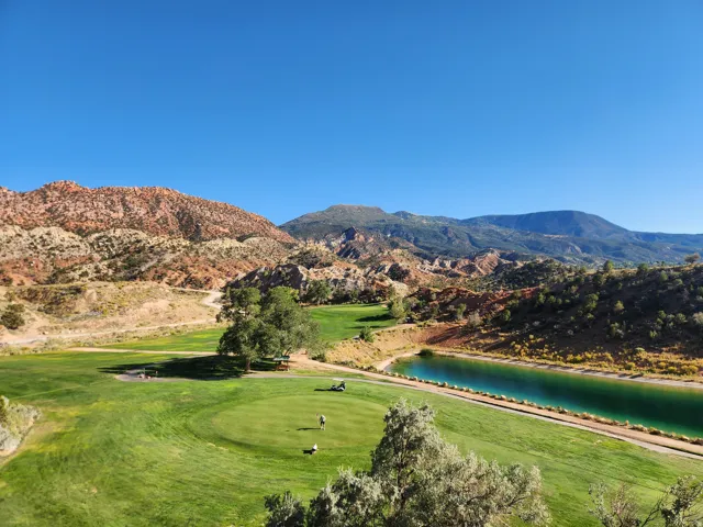 View of mountain background with a large body of water and a golf course