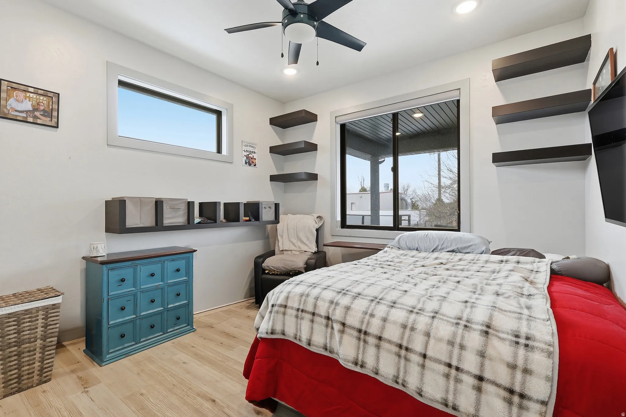 Bedroom with light wood-style floors and a ceiling fan