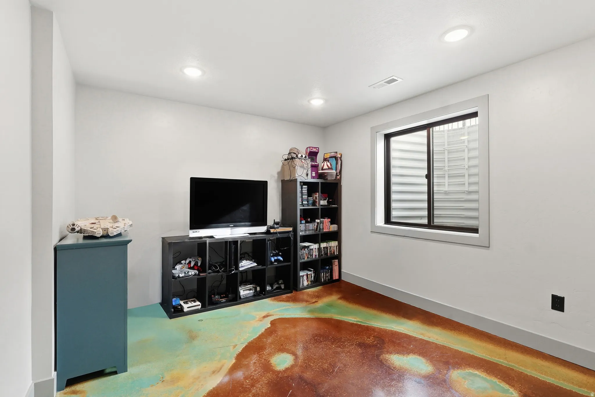 Bedroom featuring concrete flooring and recessed lighting
