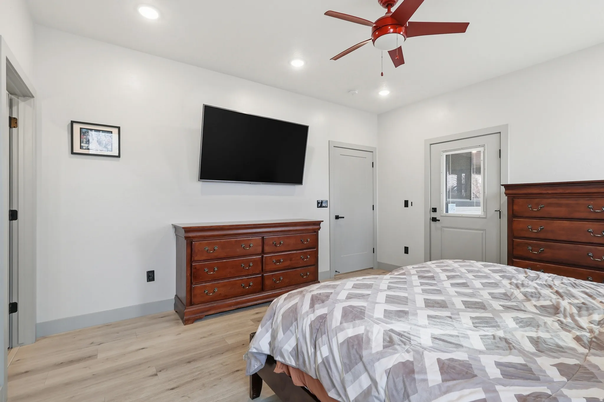Master Bedroom featuring light wood-type flooring, ceiling fan, and recessed lighting and private entrance to back covered deck.