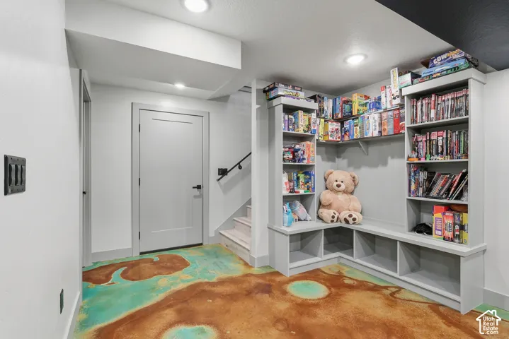 Family Room game nook featuring finished concrete floors and built in bookshelves.