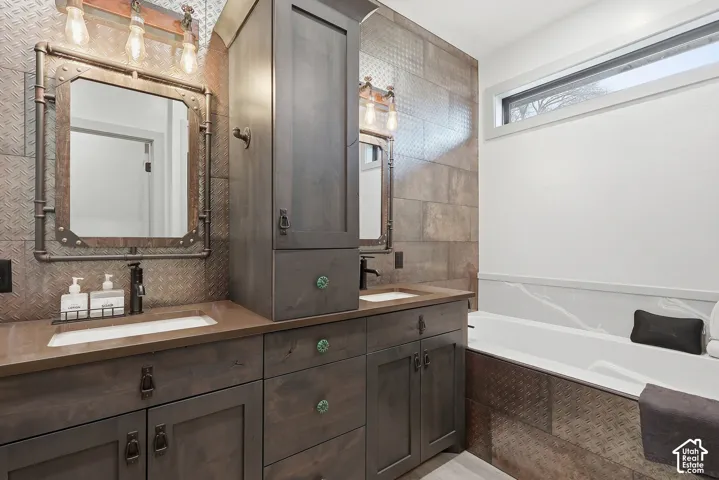 Master bathroom featuring double vanity, a garden tub, and backsplash