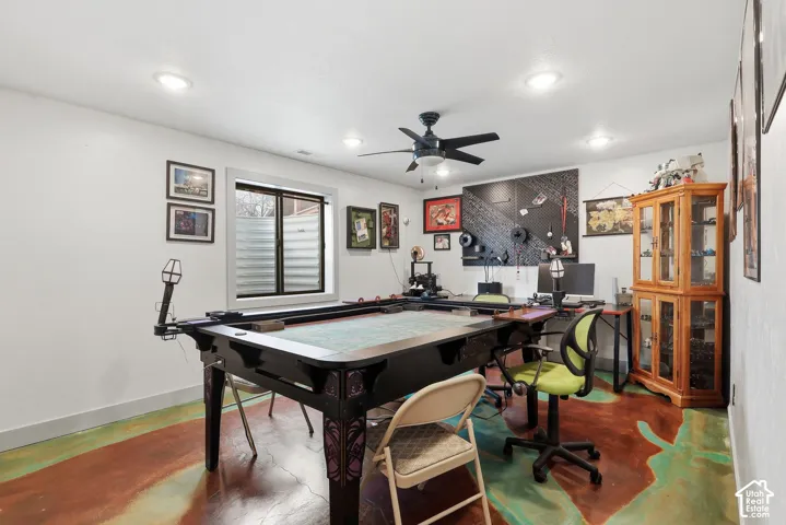 Bedroom used as a game room featuring concrete floors, a ceiling fan, and recessed lighting