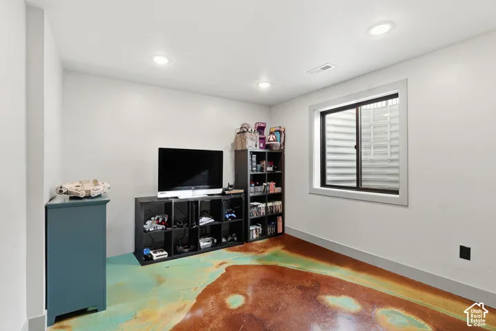 Bedroom featuring concrete flooring and recessed lighting