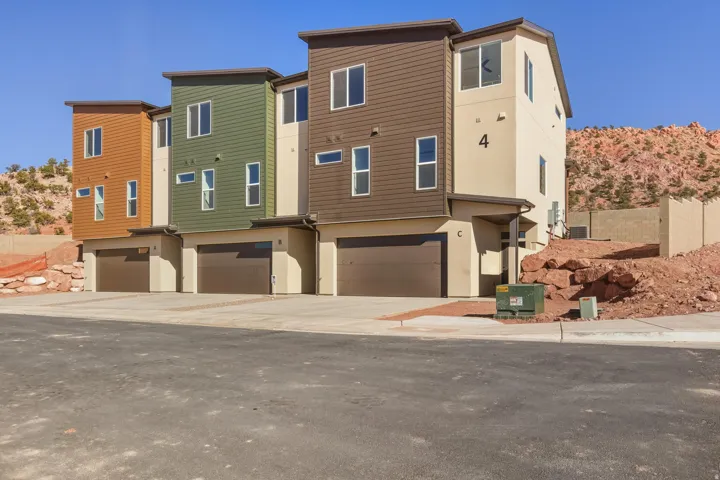 View of front facade with a garage, stucco siding, and driveway