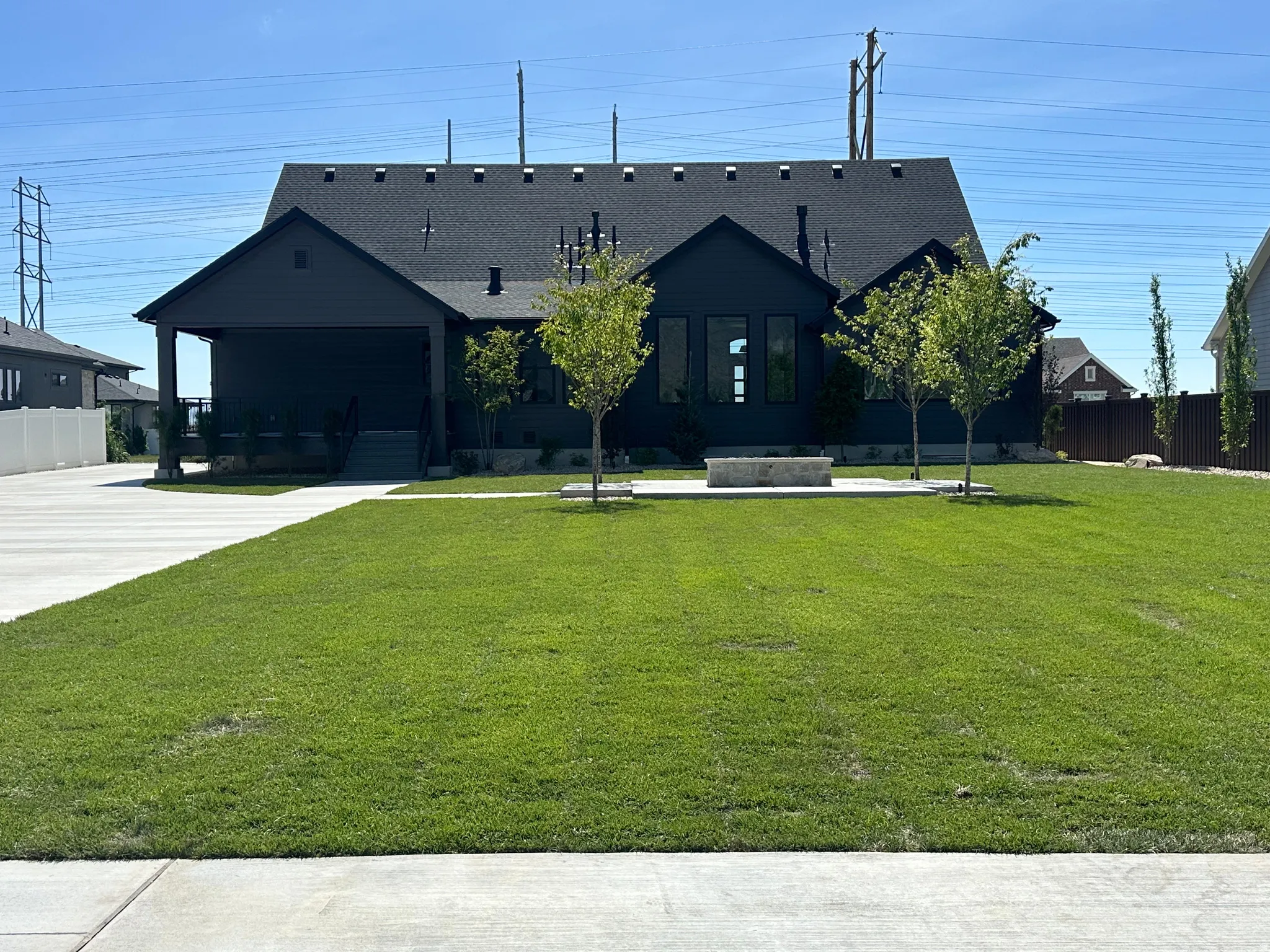 Modern dark-paneled exterior with a prominent front gabled roofline and an integrated covered entry