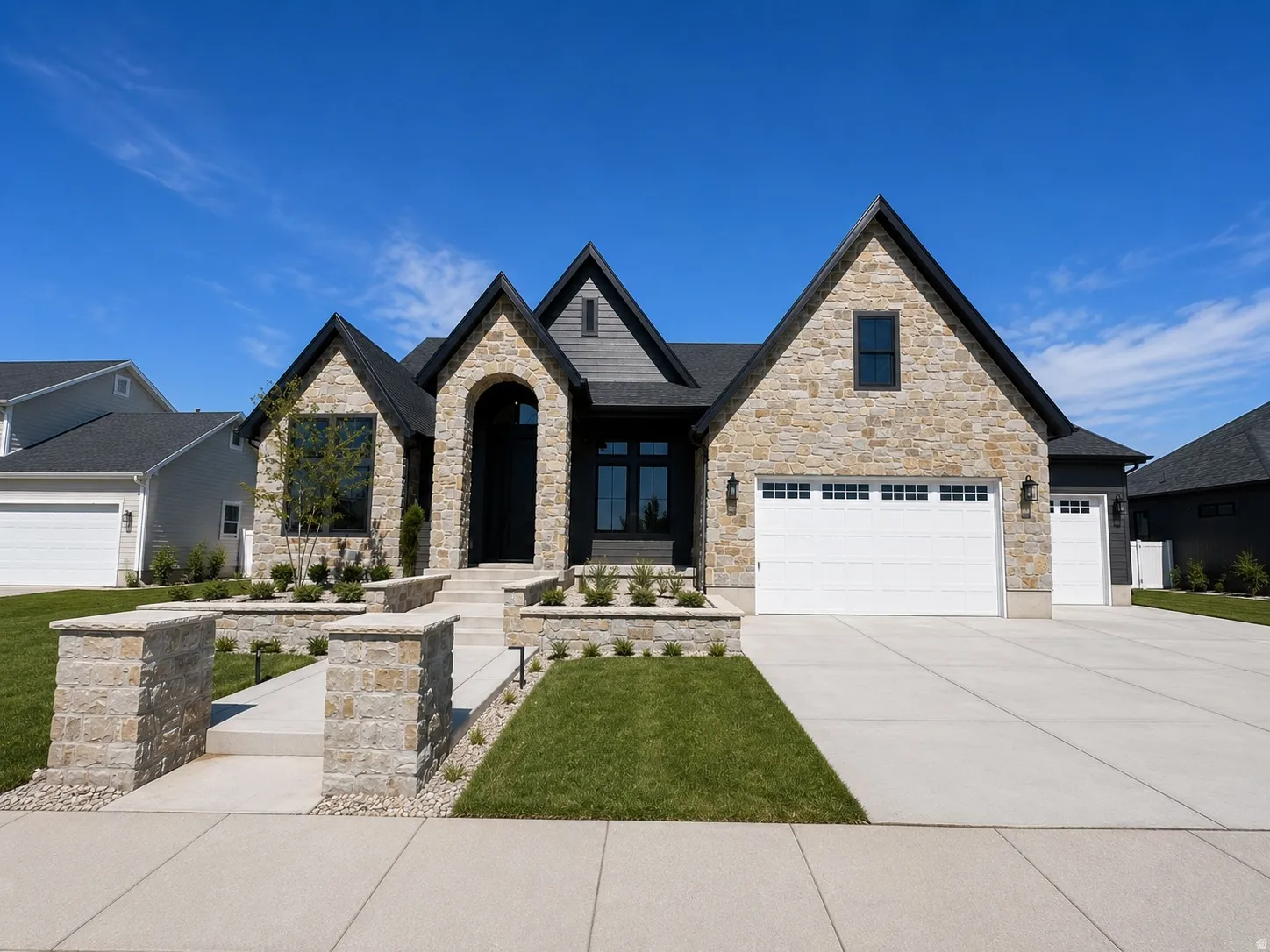 Stone and siding exterior with a prominent arched entry. 3-car garage. Landscpae