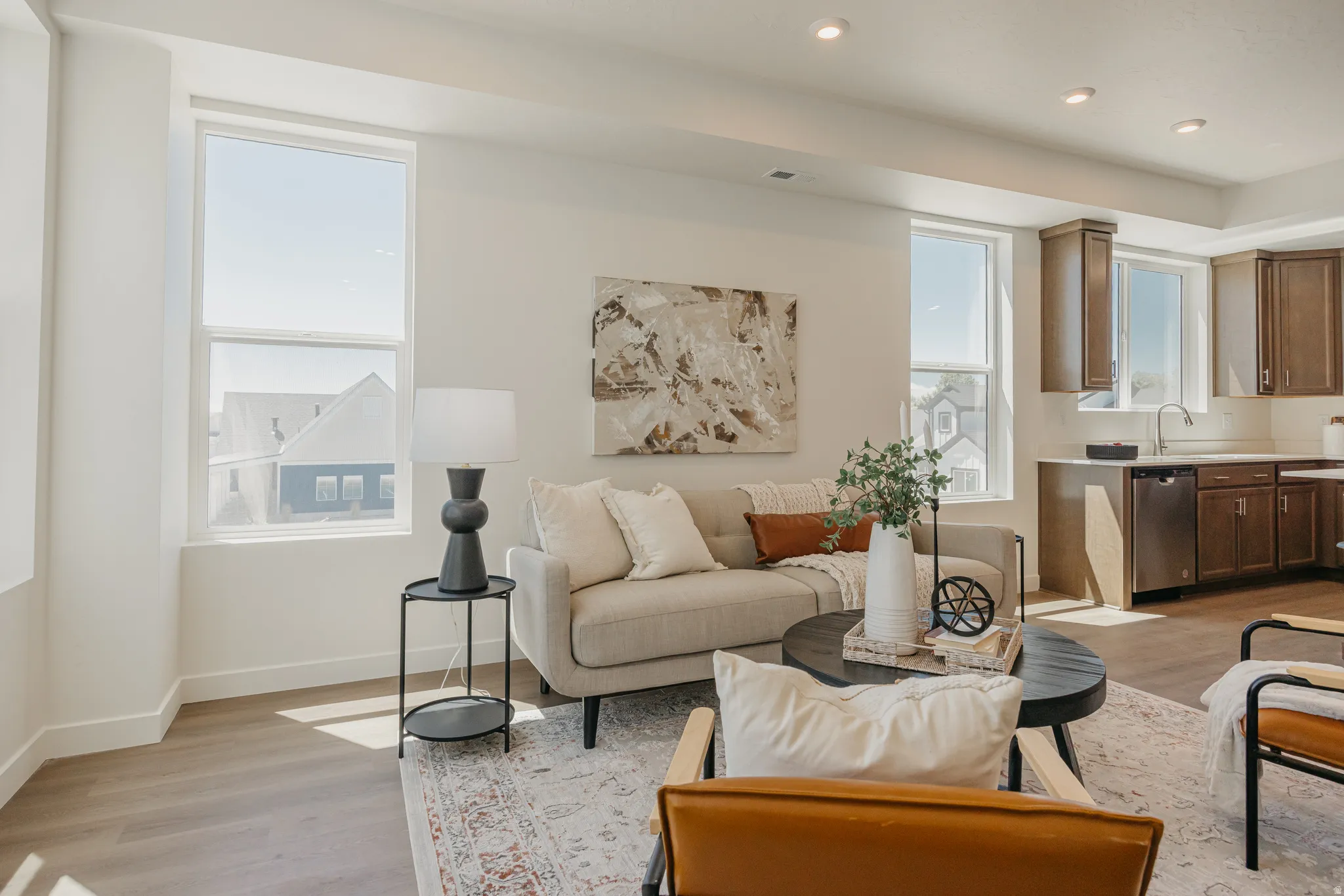 Living area with light wood-type flooring and recessed lighting