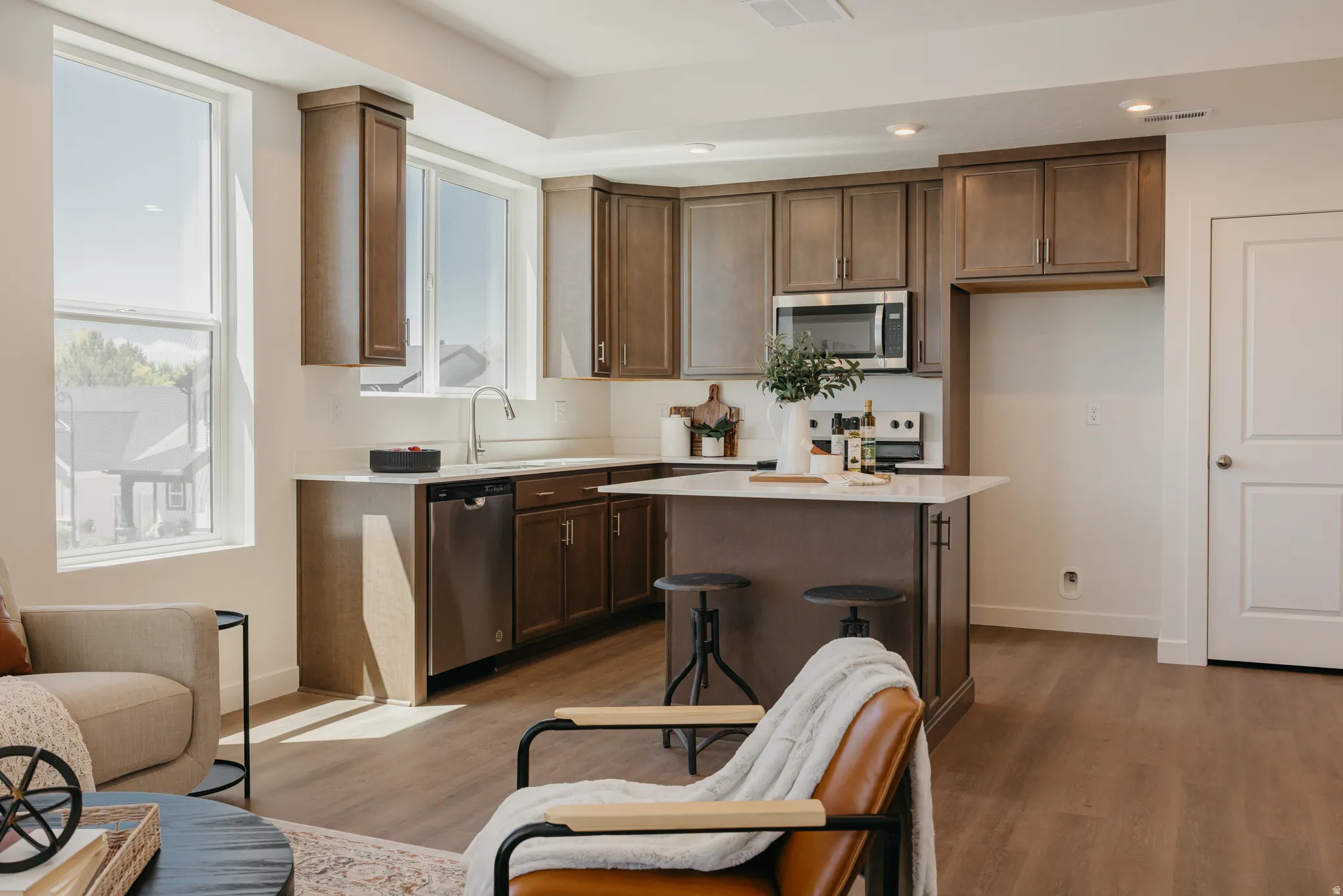 Kitchen with stainless steel appliances, light wood finished floors, recessed lighting, a kitchen island, and a kitchen breakfast bar