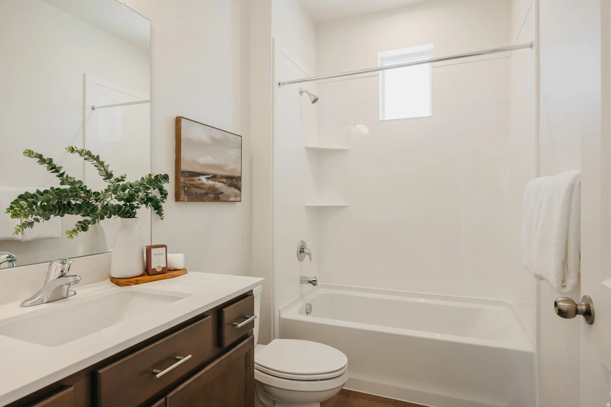 Bathroom featuring vanity, bathtub / shower combination, and dark wood-type flooring