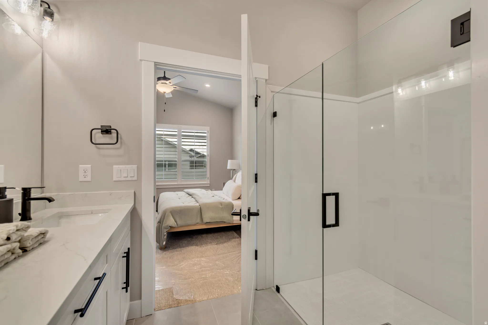 Bathroom with vanity, ensuite bath, a stall shower, a ceiling fan, and light tile patterned floors