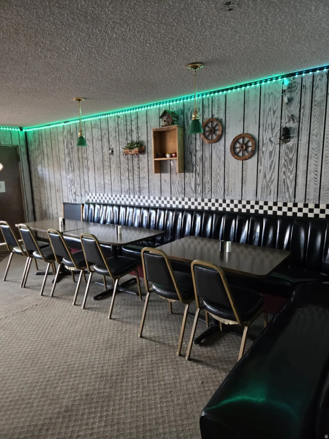 Exterior space with a textured ceiling, wooden walls, and decorative light fixtures