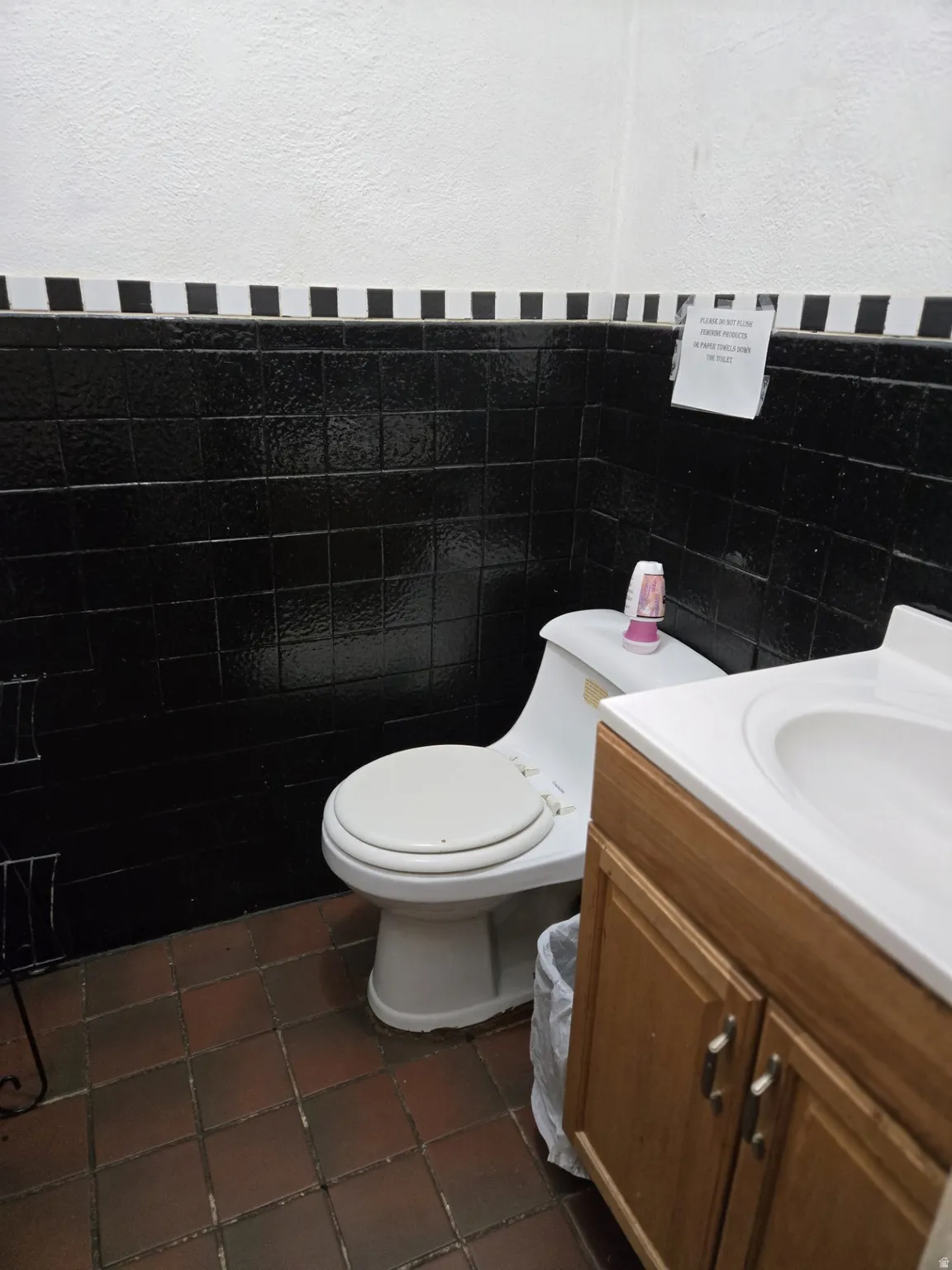 Bathroom with vanity, tile walls, dark tile patterned flooring, and a wainscoted wall