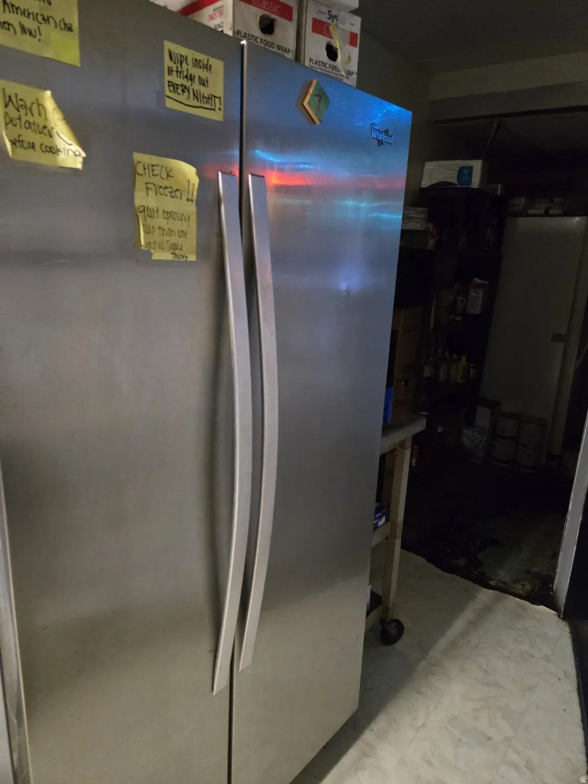 Kitchen view of freestanding refrigerator and light flooring