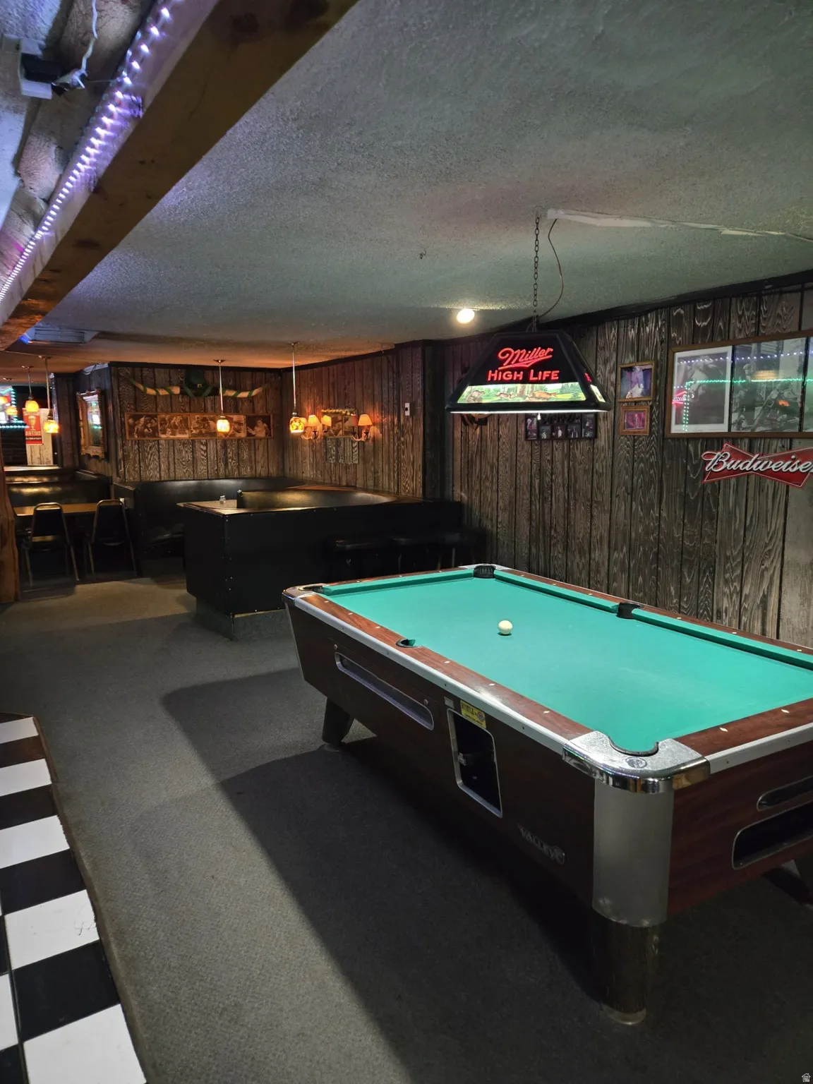 Recreation room featuring billiards, wood walls, a textured ceiling, and dark colored carpet
