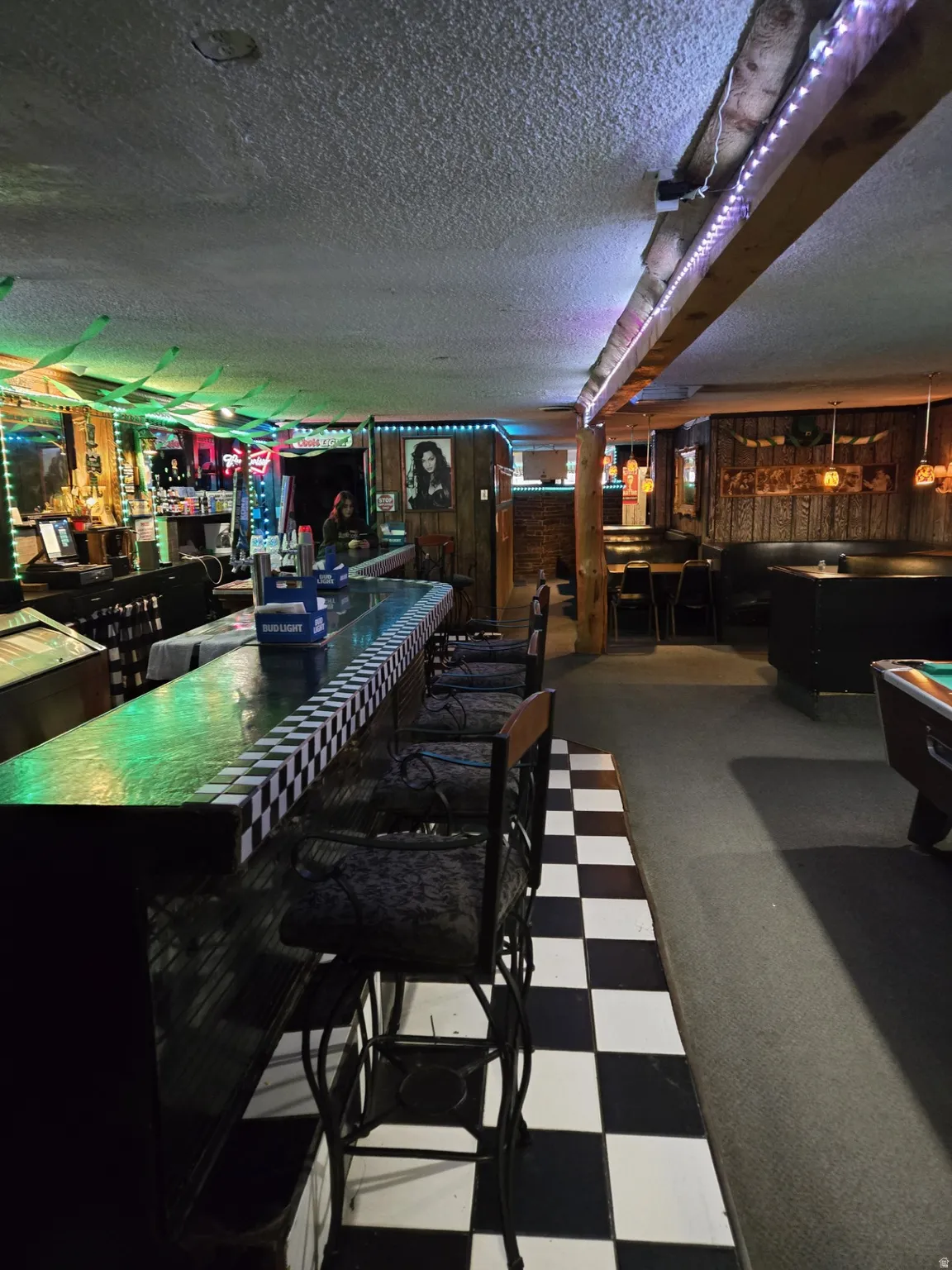 Indoor dry bar featuring billiards table, dark flooring, a textured ceiling, and dark countertops