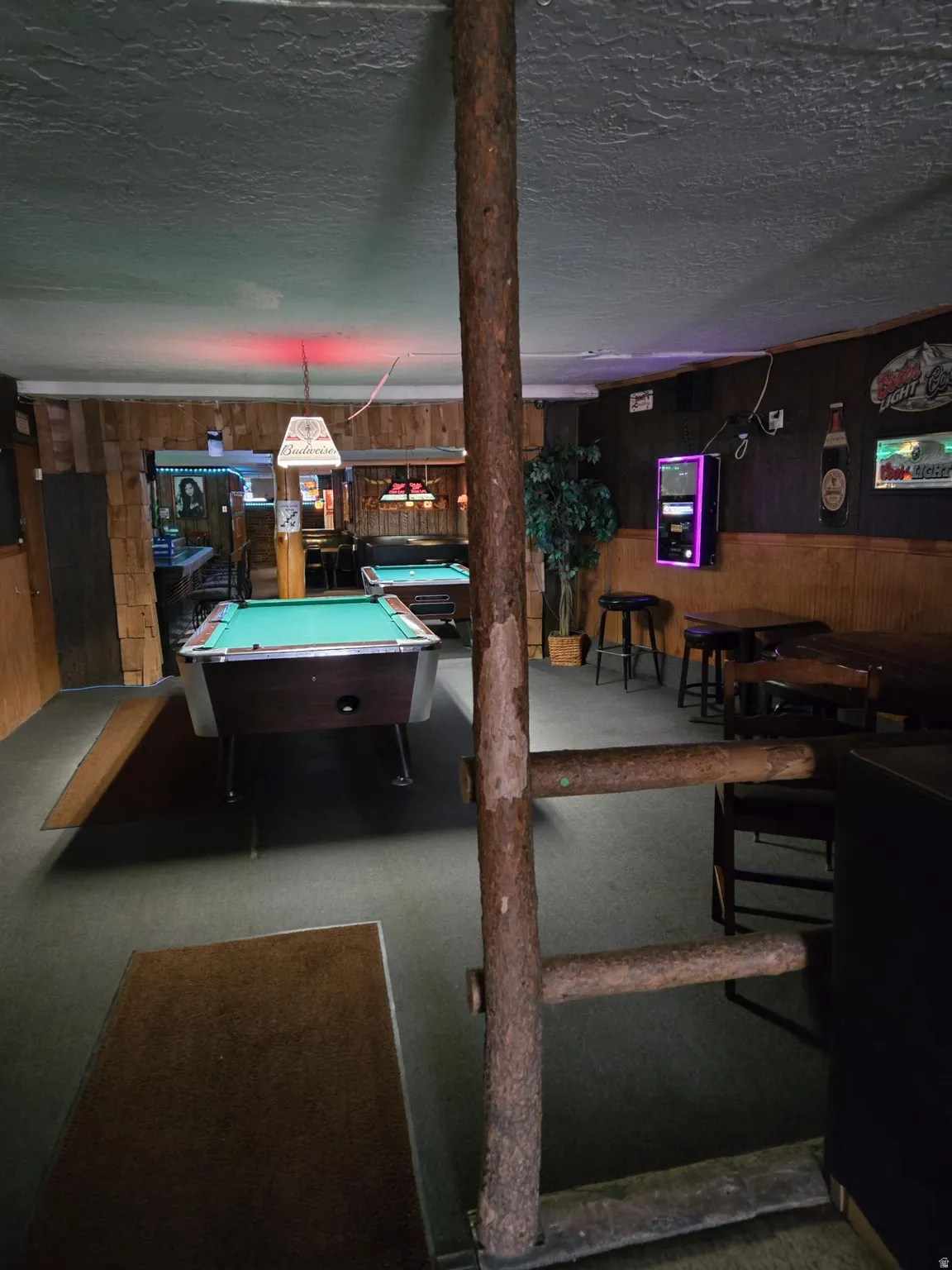 Game room featuring wood walls, pool table, and a textured ceiling