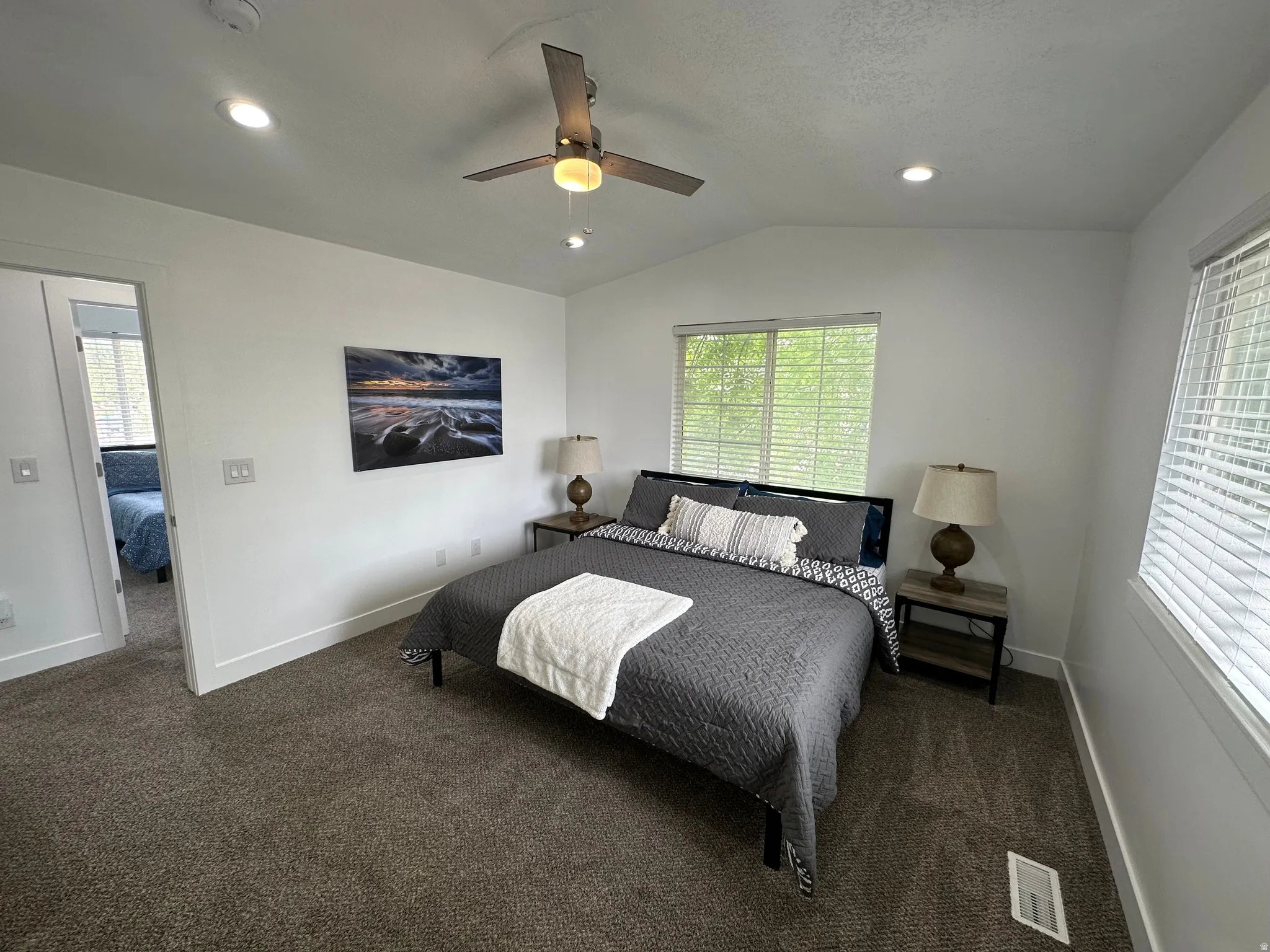 Bedroom with lofted ceiling, dark carpet, a ceiling fan, and recessed lighting
