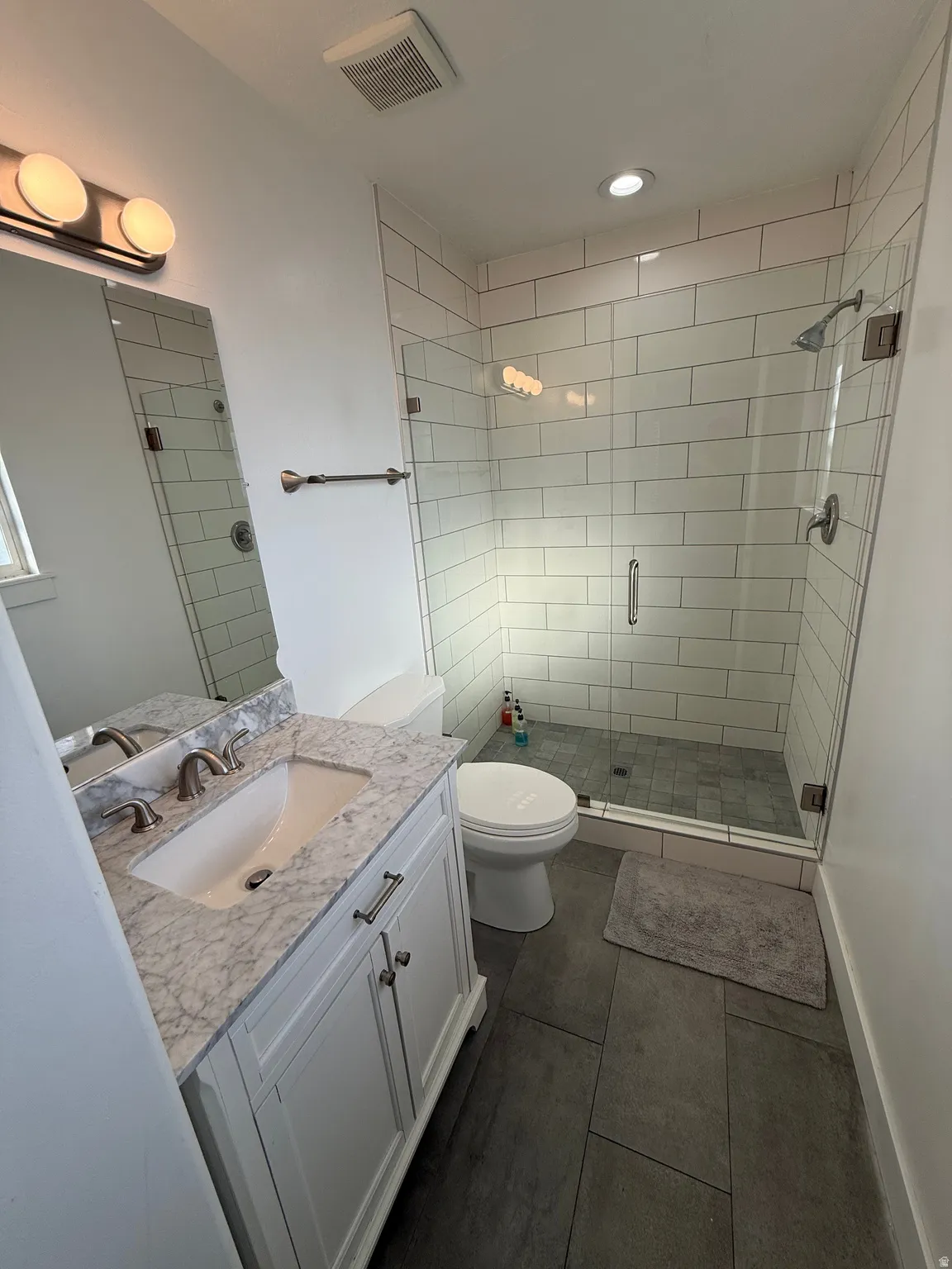 Bathroom featuring vanity, a stall shower, recessed lighting, and dark tile patterned floors