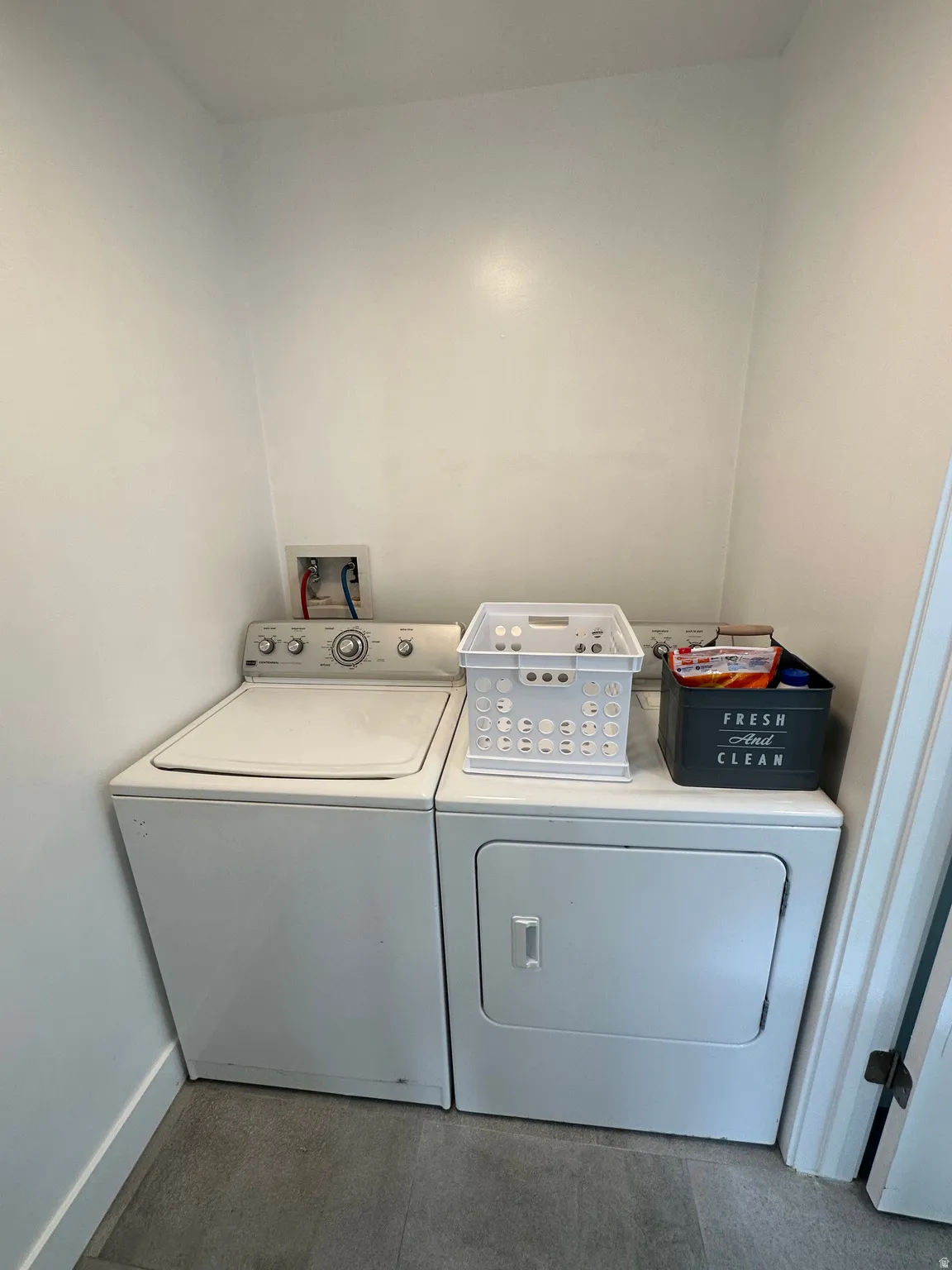 Laundry room featuring washer and clothes dryer and baseboards