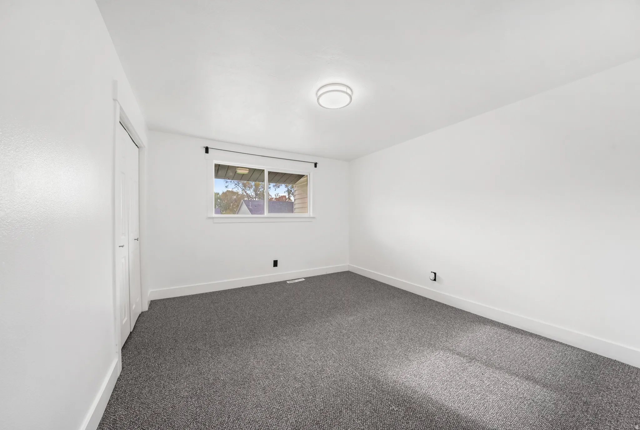 Unfurnished bedroom featuring dark colored carpet and a closet