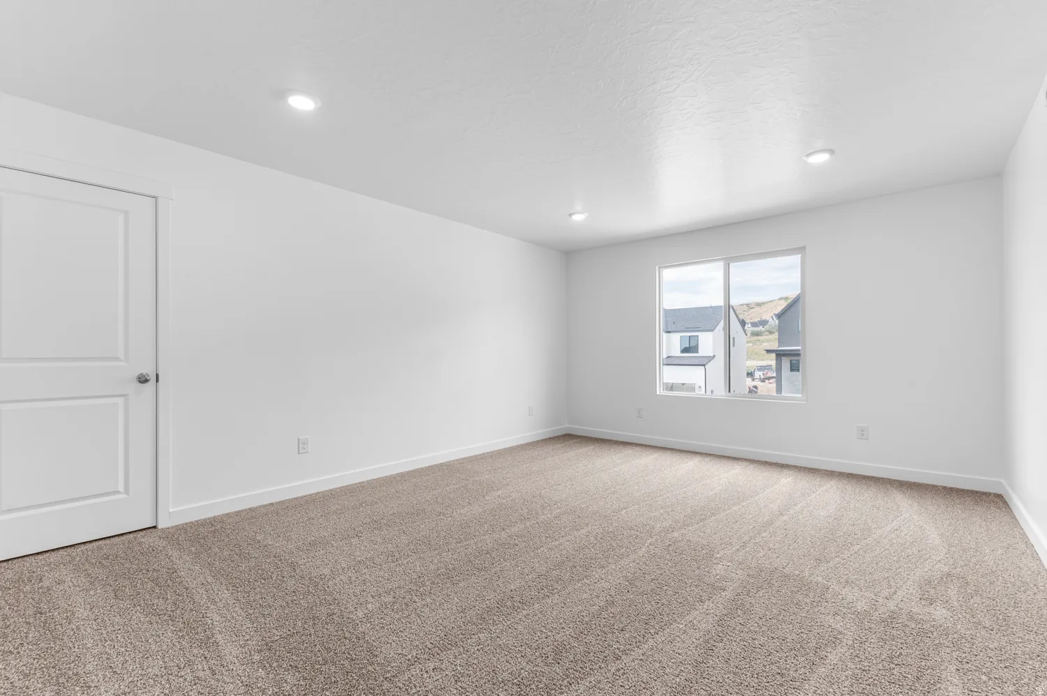 Spare room featuring light colored carpet and recessed lighting