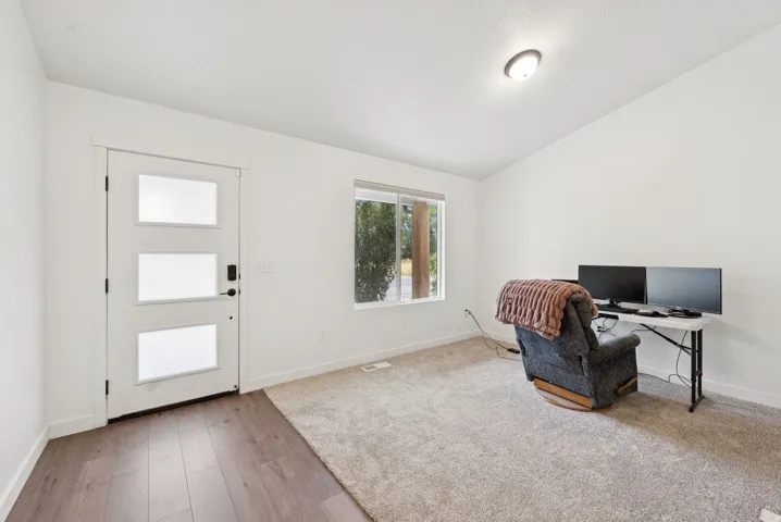 Office area with vaulted ceiling and light wood-style flooring