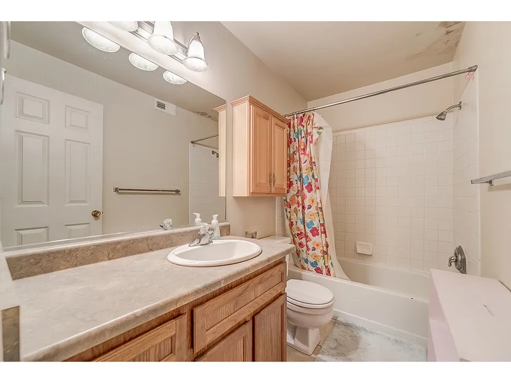 Bathroom featuring vanity and shower / bath combination with curtain