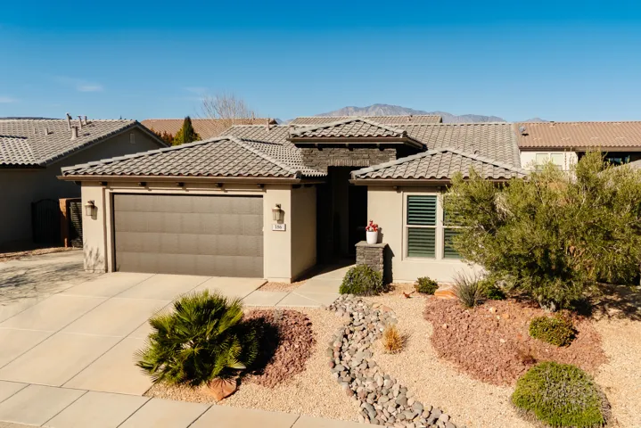 View of front facade with an attached garage, concrete driveway, stucco siding, and a mountain view