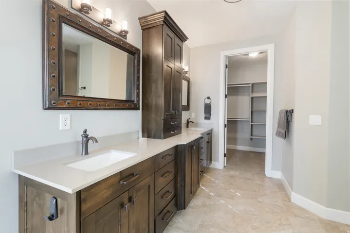 Full bath with double vanity and a spacious closet
