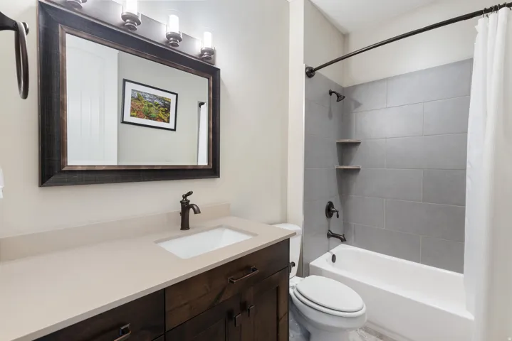 Bathroom featuring shower / bathtub combination with curtain and vanity