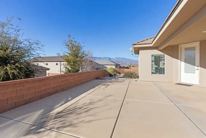Fenced backyard featuring a mountain view and a patio