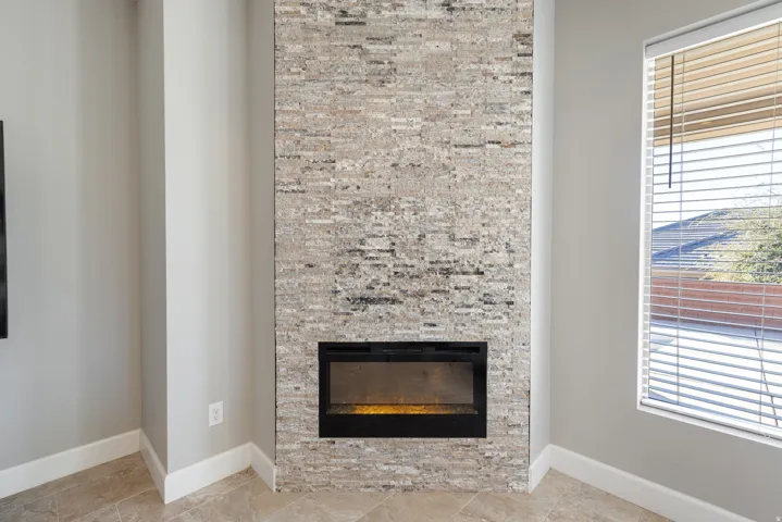 Detailed view of a glass covered fireplace and baseboards