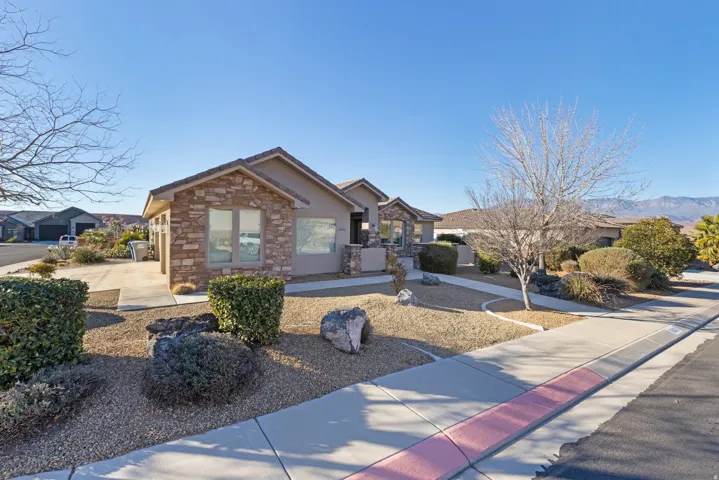 View of front of home featuring stone siding and stucco siding