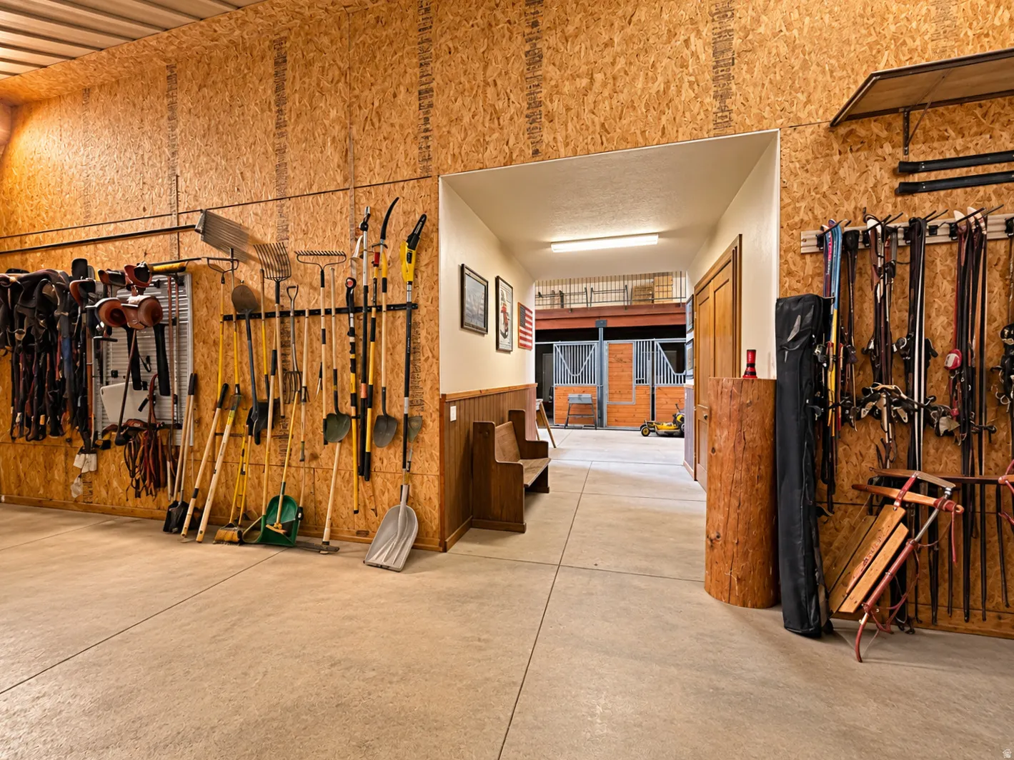 Concrete flooring, wood-finish wall paneling, built-in storage racks, and a wood bench