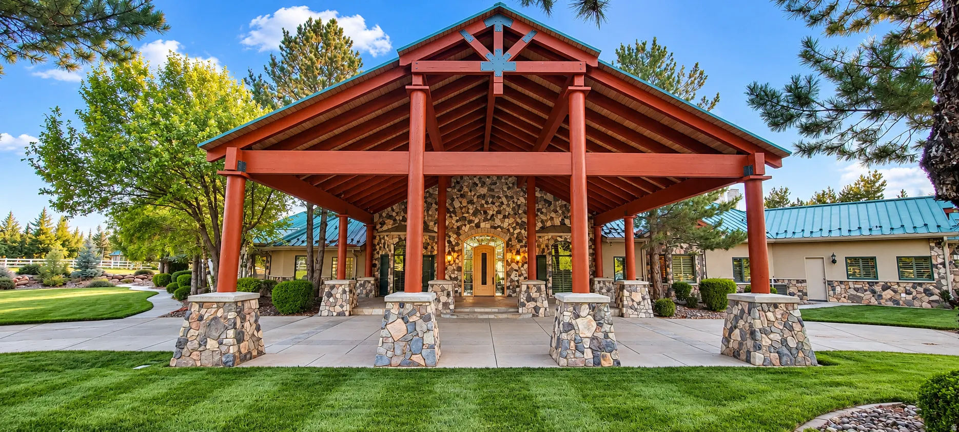 Expansive porte-cochère with exposed wood beams and stone-clad pillars