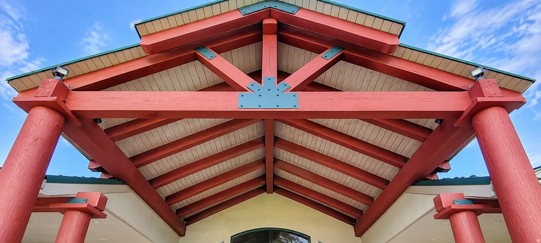 Exposed architectural beams with a distinctive red finish, supported by robust round columns