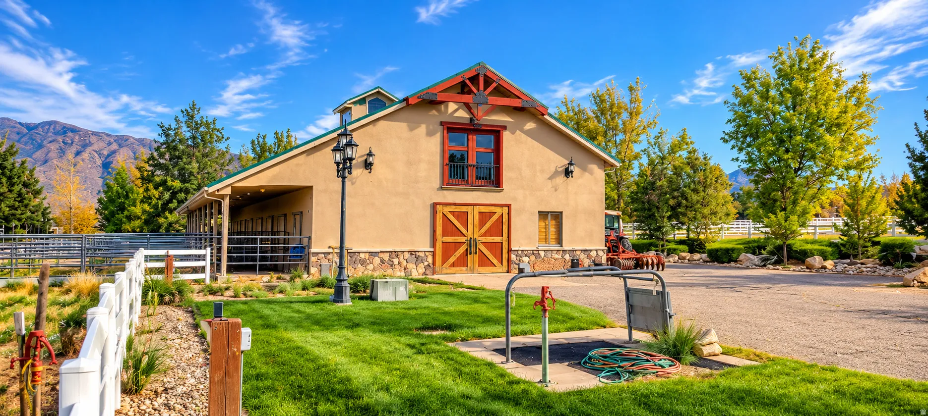 Stucco barn structure featuring stone foundational elements and wood-finish double doors