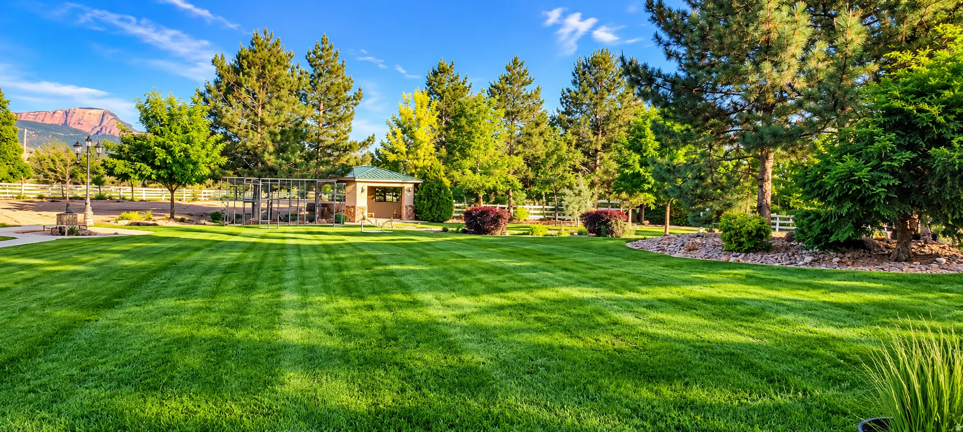 Expansive lawn with mature trees and a detached gazebo structure featuring a covered patio