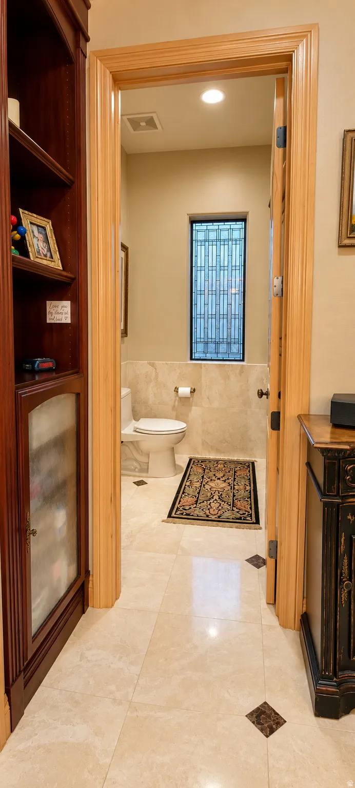 Built-in wood cabinetry, light-toned tile flooring with accent inserts, and wood door frames
