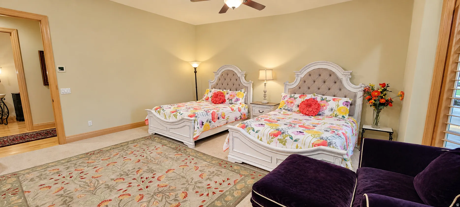 Carpeted flooring with an area rug, a ceiling fan, and wood trim details