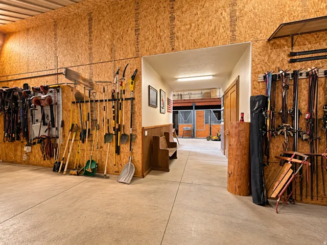 Concrete flooring, wood-finish wall paneling, built-in storage racks, and a wood bench