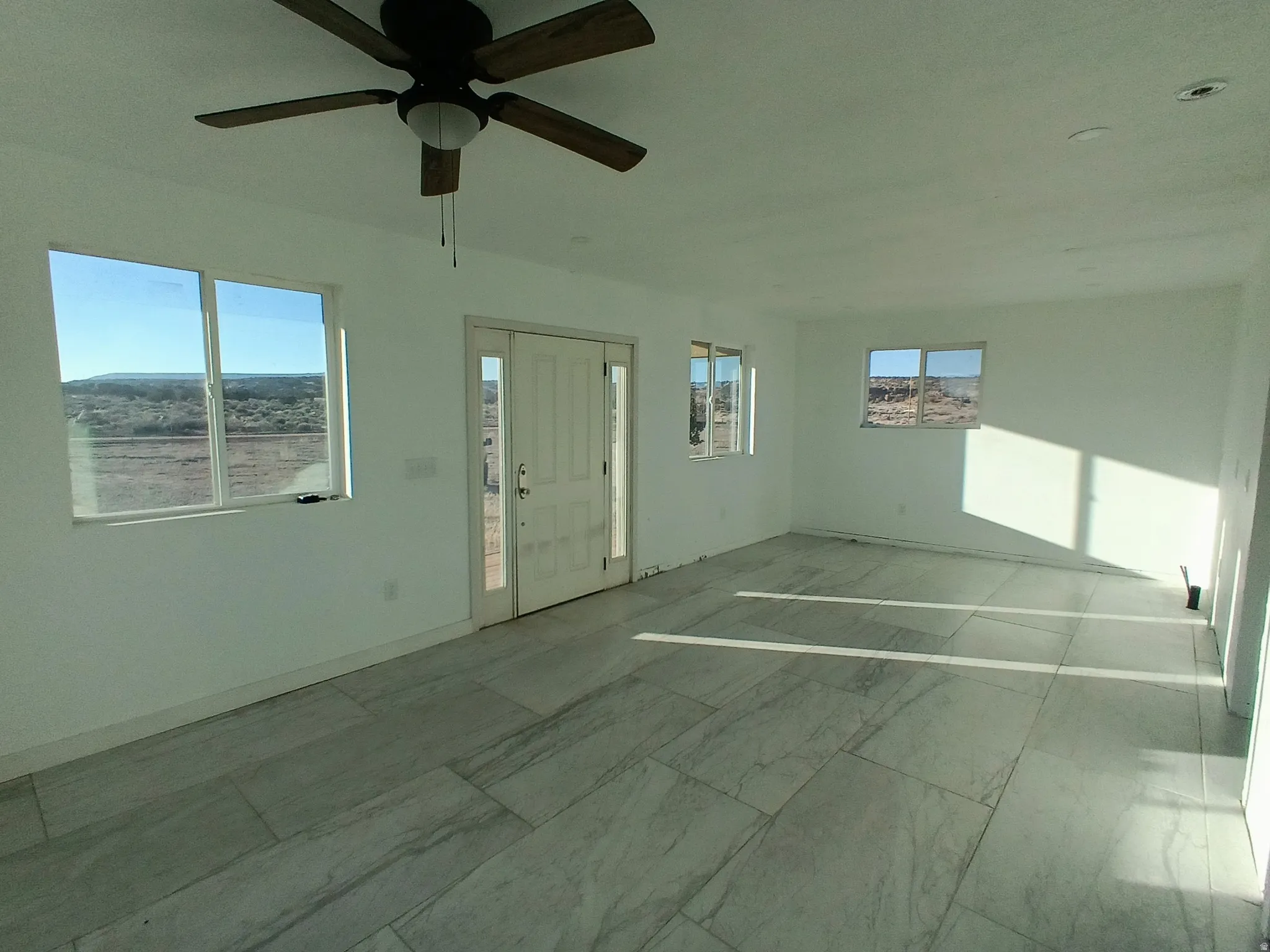 Spare room featuring baseboards and a ceiling fan