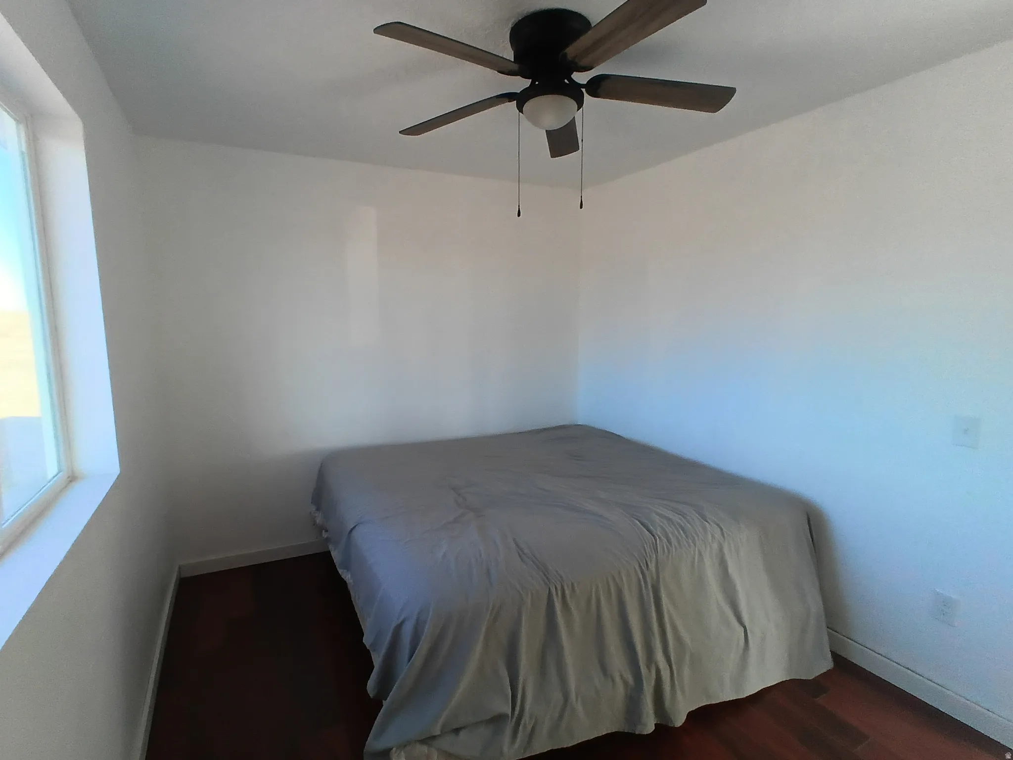 Bedroom featuring wood finished floors and a ceiling fan