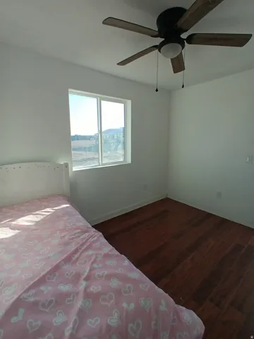 Bedroom featuring dark wood-type flooring and ceiling fan
