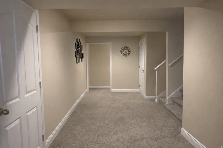 Carpeted room featuring light beige walls and white trim