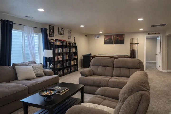 Expansive finished room featuring soft carpet flooring and recessed lighting