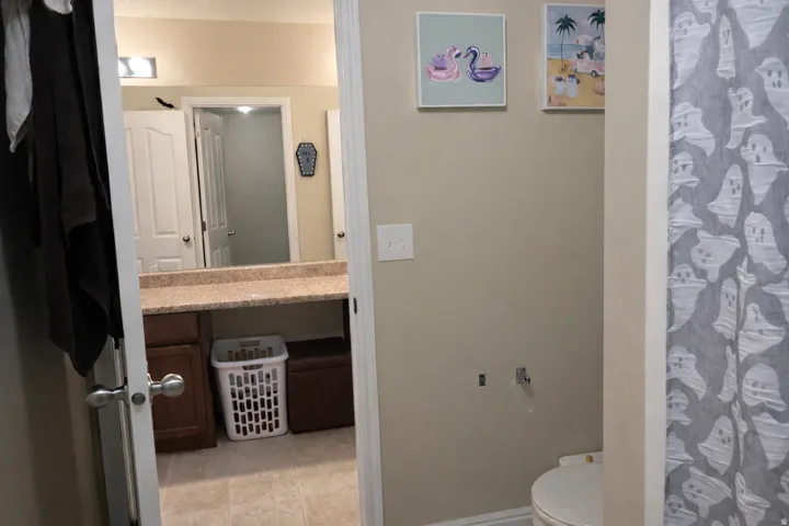 Bathroom featuring vanity, curtained shower, and light tile patterned flooring