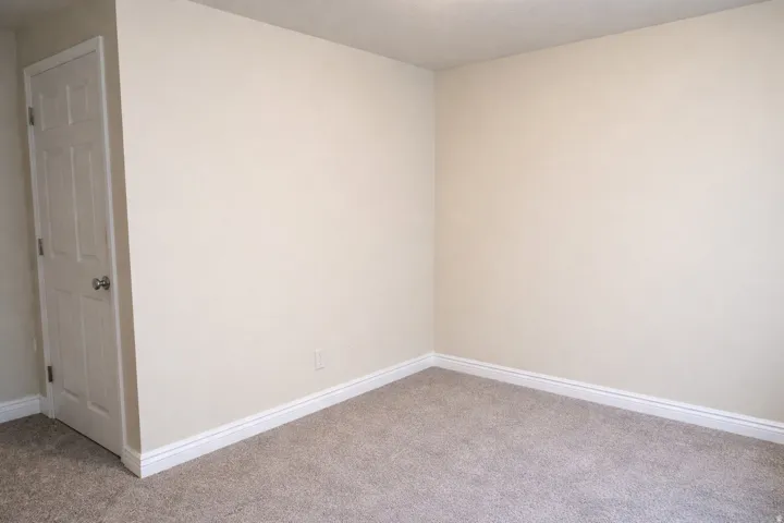 Carpeted empty room with baseboards