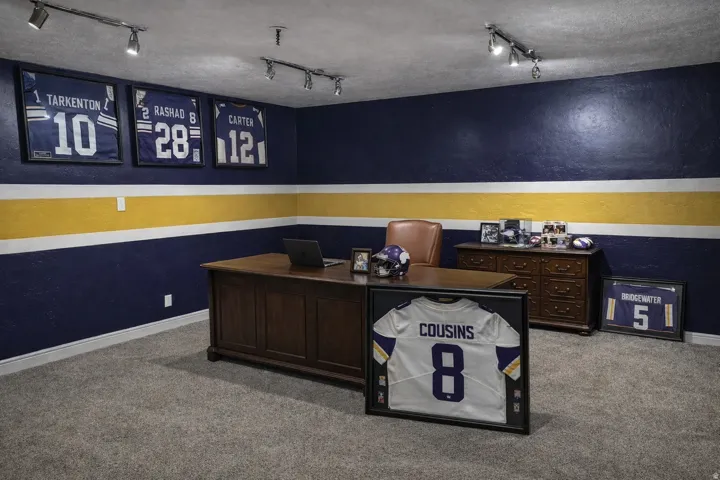 Office space featuring track lighting, light colored carpet, and a textured wall